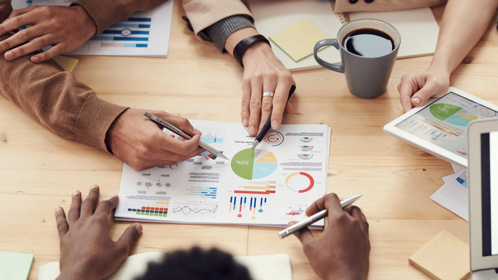 Overleg rond een tafel met grafieken en notities over de IT-aanpak